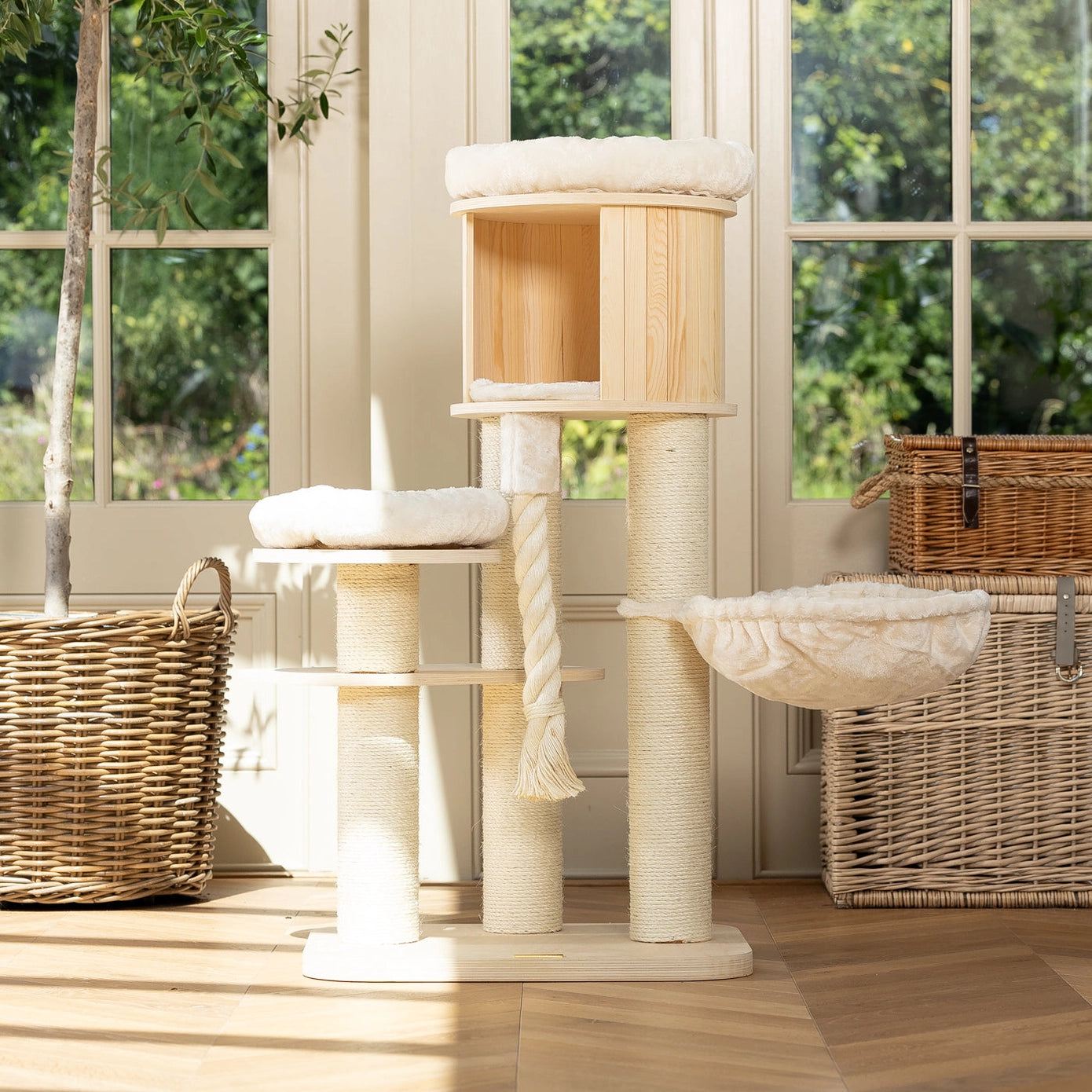 Arbre à chat en bois clair avec griffoirs en sisal, hamac suspendu et coussins moelleux, idéal pour grimper, se reposer et faire ses griffes.