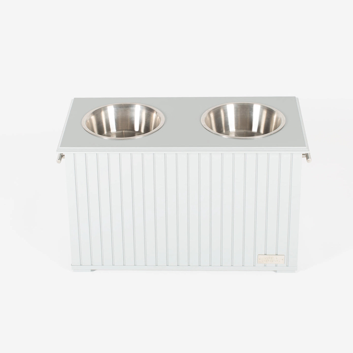 Station alimentaire blanche avec deux bols en acier inoxydable, conçue pour stocker et servir la nourriture et l’eau de manière hygiénique.