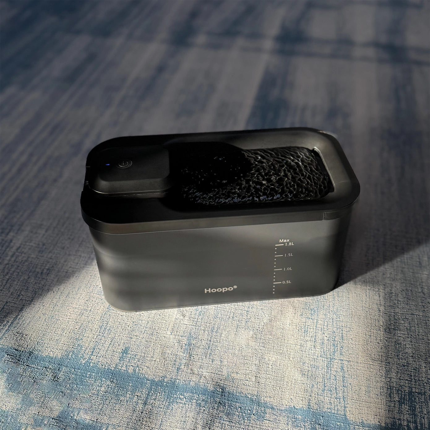 Distributeur d'eau automatique Hoopo noir, doté d'une ouverture pour boire et d'une graduation sur le côté, garantissant une hydratation constante pour les animaux.