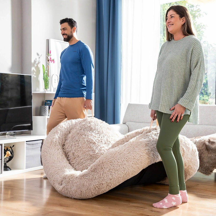 Grand panier XXL en fausse fourrure beige pour chien, lit ultra moelleux et transportable grâce à ses poignées, parfait pour offrir confort et mobilité à votre animal dans le salon ou en déplacement.

