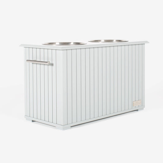 Station alimentaire blanche avec deux bols en acier inoxydable, conçue pour stocker et servir la nourriture et l’eau de manière hygiénique.